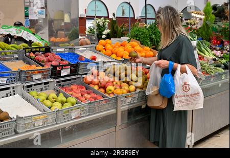 Femme magasinant des pommes à l'intérieur du marché local Mercado Coletivo Aveiro, Portugal Banque D'Images