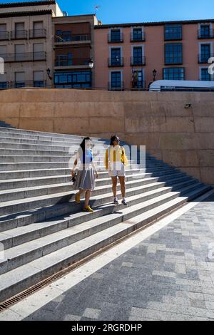 Deux amies explorant la ville. Portrait de deux amies femmes descendant un escalier à Tolède, Espagne. Banque D'Images