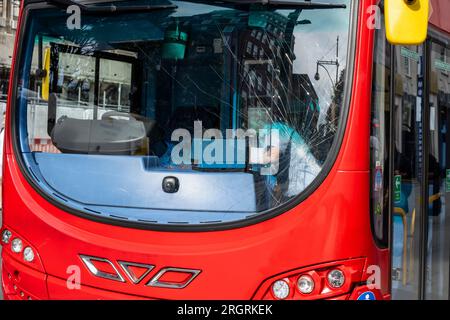 Londres, Royaume-Uni. 11 août 2023. Un homme règle les panneaux extérieurs d'un autobus à impériale, avec des dommages causés par un impact sur le pare-brise avant. Le bus a été déplacé vers un nouvel emplacement pour permettre à Oxford Street d'être rouvert à la circulation. Plus tôt, le bus a été impliqué dans un accident au coin d'Oxford Street et de New Bond Street, où, selon un rapport non confirmé, un jeune touriste se tenait trop près du bord du trottoir et a été renversé par le bus. La personne a été emmenée pour recevoir des soins médicaux et est dans un état menaçant sa vie. Crédit : Stephen Chung / Alamy Live ne Banque D'Images