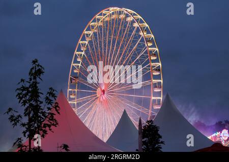 Vechta, Allemagne. 10 août 2023. Une grande roue tourne au Stoppelmarkt à Vechta. La foire a lieu une fois par an et est l'une des plus anciennes foires en Allemagne. Crédit : Friso Gentsch/dpa/Alamy Live News Banque D'Images