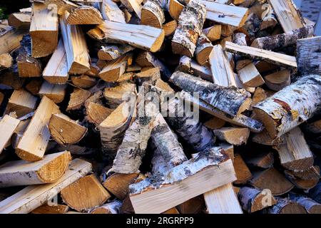 Bois de chauffage haché de bouleau empilé en pile. Clouse-up, motif. Banque D'Images