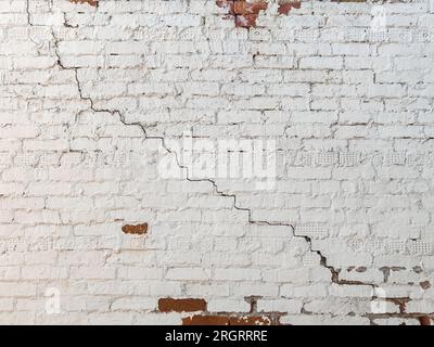 Grande fissure descendante à pas d'enroulement long sur le vieux plâtrage et mur peint. Espace de copie. Mise au point sélective. Banque D'Images