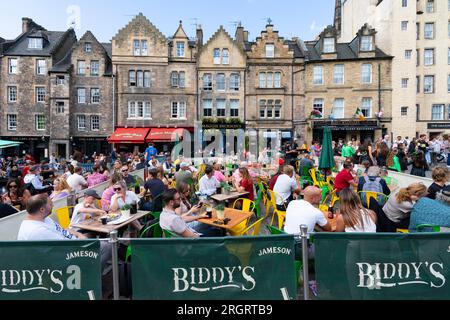 Édimbourg, Écosse, Royaume-Uni. 11 août 2023. Le soleil et les températures chaudes ont amené des milliers de visiteurs à la vieille ville d'Édimbourg lors des festivals International et Fringe aujourd'hui. Pic ; pubs et cafés dans le Grassmarket étaient tous occupés avec des visiteurs profitant des températures chaudes et du soleil. Iain Masterton/Alamy Live News Banque D'Images