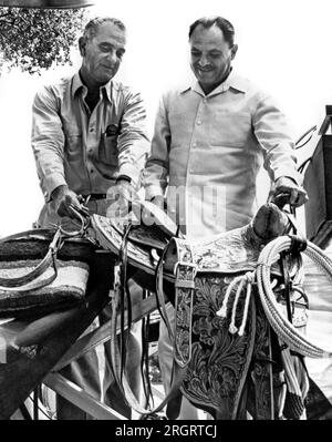 Johnson City, Texas : 16 juillet 1961 le vice-président Lyndon Johnson présente une selle de cow-boy à main au président Ayub Khan du Pakistan lors d'un barbecue au LBJ Ranch au Texas. Banque D'Images