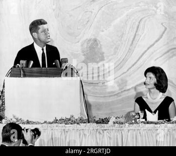 Washington, D.C. : le 20 septembre 1960 le sénateur John F. Kennedy a pris la parole ce soir lors d'un dîner de collecte de fonds à 100 $ la plaque. Sa femme, Jacqueline, observe le candidat démocrate à la présidence alors qu'il décrit son plan pour préserver et renforcer le leadership mondial des États-Unis contre les efforts du communisme. C'était son premier discours télévisé national de la campagne présidentielle. Banque D'Images