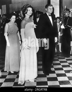 Mexico, Mexique : le 30 juin 1962 le président et Mme Kennedy se tiennent à l'attention alors que les hymnes nationaux du Mexique et des États-Unis sont joués lors d'une réception officielle à Mexico. Mme Kennedy porte une robe en mousseline de crêpe conçue par Oleg Cassini Banque D'Images