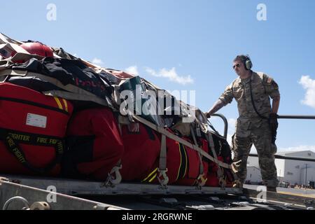 Honolulu, Hawaï, États-Unis. 10 août 2023. Le Sgt d'état-major Trevor Connors, chef d'équipage dédié de la 154e unité de maintenance d'aéronefs, charge des fournitures sur un C-17 Globemaster III, le 10 août 2023, à la base interarmées Pearl Harbor-Hickam, Hawaii. Des fournitures, des véhicules et du personnel du service des incendies d'Honolulu ont été transportés sur l'île de Maui pour aider à lutter contre les incendies de forêt qui ont touché l'île. Un équipage de la garde nationale aérienne d'Hawaii du 204th Airlift Squadron a exploité l'avion pour fournir des ressources de secours aux communautés touchées. (Image de crédit : © John Linzmeier/États-Unis Garde nationale/ZUMA CRE Banque D'Images