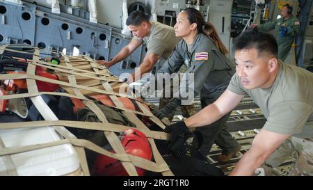 Honolulu, Hawaï, États-Unis. 10 août 2023. Les capitaines de chargement et les spécialistes de la maintenance de la garde aérienne d'Hawaii déchargent des fournitures d'un C-17 Globemaster III, le 10 août 2023, à l'aéroport de Kahului, Maui, Hawaii. Les aviateurs de la garde nationale aérienne d'Hawaii ont transporté 37 membres du service d'incendie d'Honolulu et des cargaisons de secours en cas de catastrophe pour aider les communautés touchées par plusieurs incendies de forêt. (Image de crédit : © John Linzmeier/États-Unis National Guard/ZUMA Press Wire) À USAGE ÉDITORIAL UNIQUEMENT ! Non destiné à UN USAGE commercial ! Crédit : ZUMA Press, Inc./Alamy Live News Banque D'Images