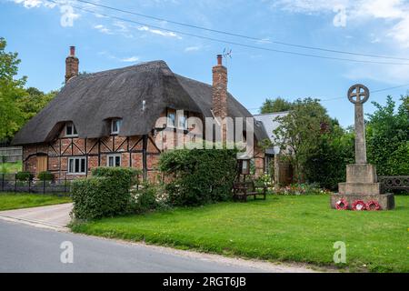 Mémorial de guerre dans le village de Longstock, Hampshire, Angleterre, Royaume-Uni, à côté d'un chalet en chaume Banque D'Images