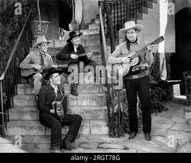 Ray Whitley (debout, guitare acoustique) et les six Bar Cowboys, sur le plateau du film, 'Renegades du Rio Grande', Universal Pictures, 1945 Banque D'Images