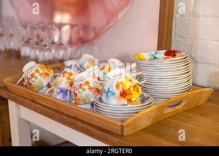 Les tasses et soucoupes multicolores pour boire du thé sont séchées dans la cuisine Banque D'Images