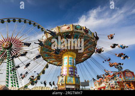 Herne, Allemagne. 11 août 2023. Un manège traditionnel de manège de swing s'avère populaire. Les gens sur une promenade à sensations fortes. La fête foraine sur sa journée la plus chargée jusqu'à présent, sous un beau soleil et des températures chaudes attirant la foule. La foire de Cranger kirmes est l'une des plus grandes d'Allemagne. La foire populaire attire régulièrement plus de 4 millions de visiteurs au cours de ses 10 jours de course, la grande majorité d'entre eux ayant assisté au dernier week-end. La foire remonte au début du 18e siècle à Crange. Crédit : Imageplotter/Alamy Live News Banque D'Images