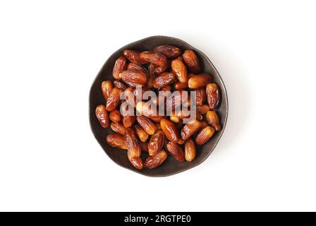 Dattes séchées dans une plaque isolée sur fond blanc. Cuisine arabe traditionnelle. Vue de dessus, pose à plat. Banque D'Images