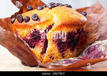 délicieux cupcake de blé avec des morceaux de chocolat en gros plan sur une vieille table de cuisine, garniture aux myrtilles, cupcakes à la farine et au cacao en gros plan, desserts et autres Banque D'Images