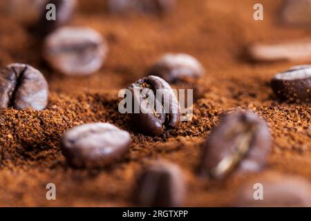 la poudre de grain de café, et les grains de café entiers, les grains de café torréfiés sont placés sur le café moulu, ingrédients pour faire une boisson chaude et revigorante Banque D'Images