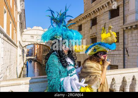 Venise, Italie - 28 février 2022 : un couple vêtu de costumes traditionnels se trouve devant le pont des Soupirs, partie du carnaval du masque de Venise, Ven Banque D'Images