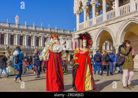 Venise, Italie - 28 février 2022 : groupe vêtu de costumes traditionnels, dans le front de mer de Riva degli Schiavoni, partie du carnaval du masque de Venise, Vénétie Banque D'Images