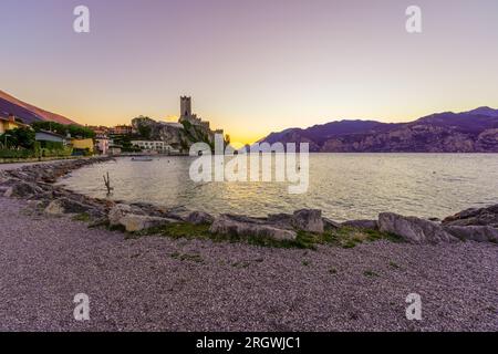 Coucher de soleil vue sur la forteresse de Malcesine, rive est du lac de Garde, par une journée claire d'hiver, à Malcesine, Vénétie, Italie du Nord Banque D'Images