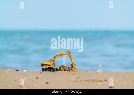 Pelle hydraulique modèle Caterpillar sur le rivage sablonneux Banque D'Images