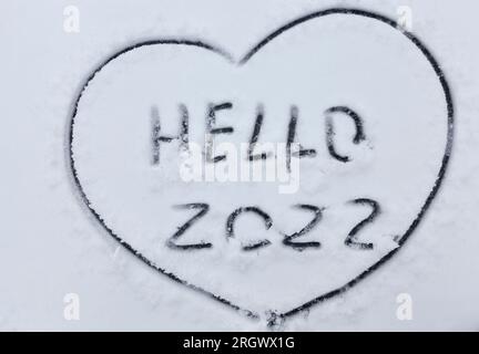 les chiffres et le mot bonjour est dessiné sur la neige dans la saison d'hiver, l'inscription sur la nouvelle année 2022 Banque D'Images