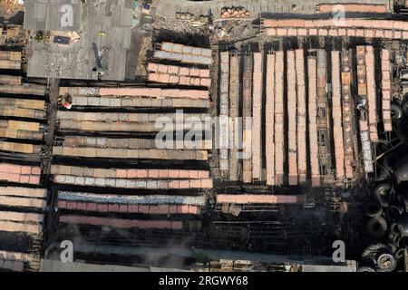 Jakarta. 12 août 2023. Cette photo aérienne prise le 12 août 2023 montre des ouvriers qui séchent des poissons transformés à Cilincing, dans le nord de Jakarta, en Indonésie. Cilincing dans le nord de Jakarta est l'un des villages de pêcheurs de Jakarta. Crédit : Veri Sanovri/Xinhua/Alamy Live News Banque D'Images