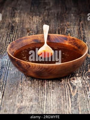 miel naturel dans un grand bol en bois avec une cuillère en bois, le miel peut être utilisé dans les procédures cosmétiques, pour donner à la peau beauté et douceur, traitement de beauté Banque D'Images