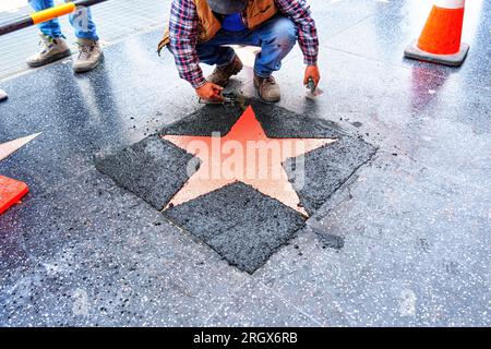 Vue de haut en bas du processus de pose d'une nouvelle étoile de corail sur le Walk of Fame à Hollywood, Californie. Banque D'Images