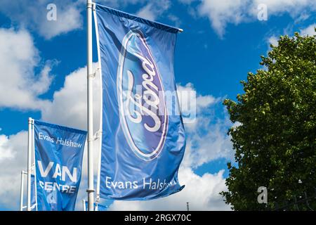 Wolverhampton, Royaume-Uni - août 11 2023 : une bannière drapeau avec le logo Ford devant le concessionnaire Evans Halshaw Ford à Wolverhampton, Royaume-Uni Banque D'Images