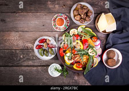 Set collection de fromages et de collations. Halloumi grillé, knolle belper, olives, sauce tzatziki sur fond rustique en bois ancien. Frais généraux. Copier spac Banque D'Images