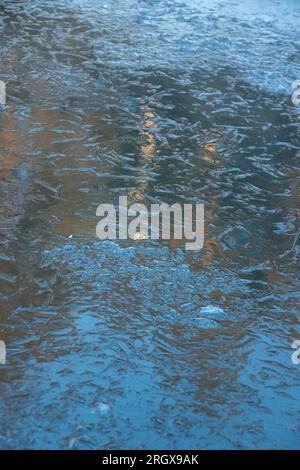 Glace fissurée sur un lac gelé. La texture naturelle de la glace d'hiver avec des bulles blanches et des fissures sur un lac gelé. lac transparent recouvert de glace Banque D'Images