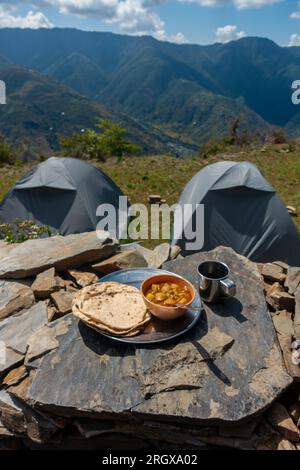 Plateau de nourriture indien Roti-Sabzi (pain indien et curry de légumes) en plein air pendant le camping dans l'Himalaya. Uttarakhand Inde. Banque D'Images