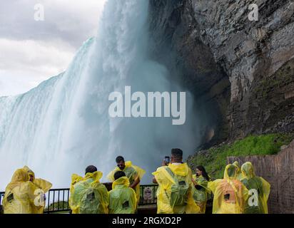 Chutes du Niagara, Ontario, Canada - 31 juillet 2023 : vue arrière des touristes prenant des photos des chutes portant une oreille de pluie jaune sur une plate-forme d'observation sous Banque D'Images