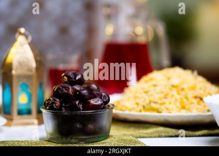 Gros plan des dates placées sur la table à manger pour manger après le jeûne pendant le dîner du festival du ramadan - concept de dîner de l'iftar, du ramadan et de la tradition Banque D'Images