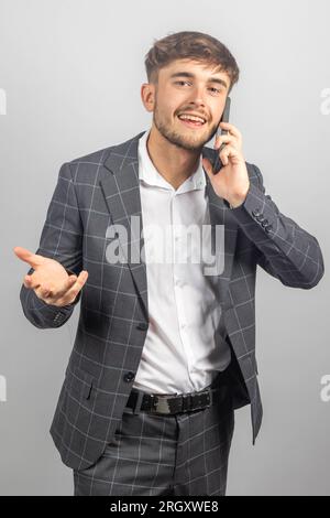 Portrait d'un jeune homme d'affaires ou entrepreneur dans un jacked et une chemise à col ouvert parlant sur un téléphone moblie Banque D'Images