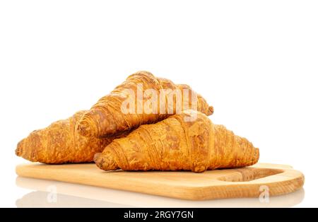 Trois croissants parfumés avec garniture au chocolat sur une planche de bois, gros plan, isolés sur blanc. Banque D'Images