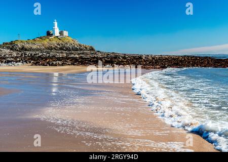 Phare de Mumbles vu de Bracelet Bay sur Mumbles, près de Swansea, au sud du pays de Galles photographié en février sous un ciel bleu clair Banque D'Images