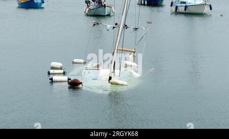 Bateau partiellement submergé avec mouette debout près du mât Banque D'Images