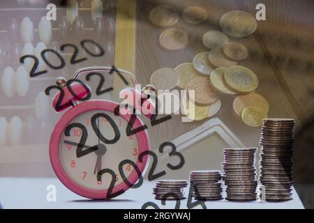 Liste de 2022 et 2023 sur papier sur fond de pièces de monnaie, calculatrice et billets sur la table, les affaires et les finances dans l'année Banque D'Images
