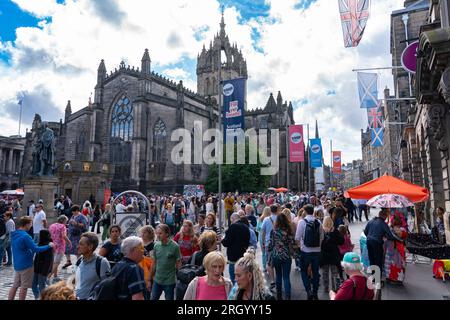 Édimbourg, Écosse, Royaume-Uni. 12 août 2023. Les températures chaudes et le soleil ont vu des milliers de visiteurs dans le centre-ville d'Édimbourg pendant les festivals International et Fringe. Le Royal Mile était extrêmement occupé alors que le public venait regarder des artistes de rue. Pic ; les rues étaient remplies de touristes et d'habitants comme ici sur le Royal Mile. Iain Masterton/Alamy Live News Banque D'Images