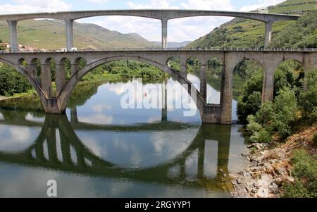 Ponts traversant le fleuve Douro à l'est de Porto dans la région viticole portugaise, vignobles en terrasse sur les pentes en arrière-plan, Peso da Regua, Portugal Banque D'Images