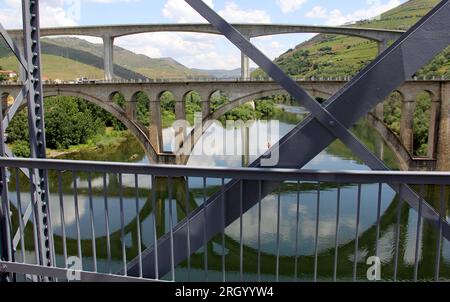 Ponts traversant le fleuve Douro à l'est de Porto dans la région viticole portugaise, vignobles en terrasse sur les pentes en arrière-plan, Peso da Regua, Portugal Banque D'Images