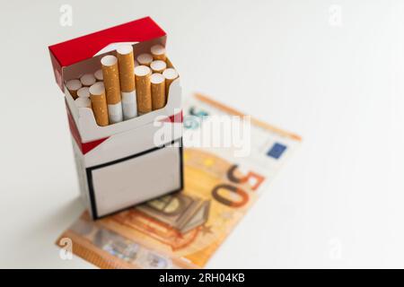 Billets de 20 et 50 euros billets de caisse avec cigarettes, avec boîte à cigarettes. Concept de coût du tabac, cigarettes. Vue avant et vue de dessus, gros plan. Activé Banque D'Images