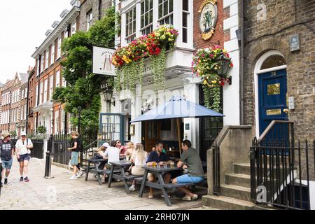 Les gens assis et prenant un verre devant la maison publique Cricketers sur Richmond Green, Richmond, TW9, Surrey, Angleterre, ROYAUME-UNI Banque D'Images