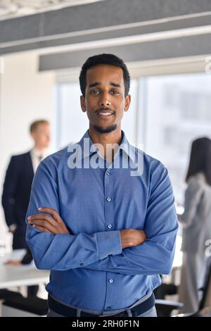 Homme d'affaires afro-américain confiant debout dans le bureau, portrait vertical. Banque D'Images