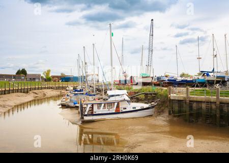 Bateaux amarrés reposant sur les rives boueuses à marée basse sur la rivière Rother à Rye Harbour, un petit village côtier près de la ville de Rye dans l'East Sussex Banque D'Images