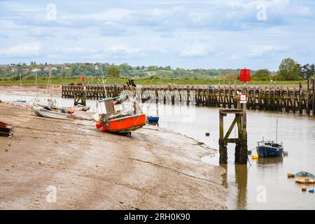 De petits bateaux échoués à marée basse sur les rives de la rivière Rother, amarrés à Rye Harbour, un petit village près de la ville de Rye près de la côte dans l'East Sussex Banque D'Images