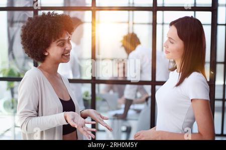 Deux femmes analysant des documents bureau. Les cadres féminins au travail au bureau discutent de certains documents administratifs. Banque D'Images