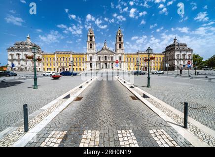Palais national de Mafra, Portugal. Grand complexe royal baroque et néoclassique avec basilique et tours jumelles sous un ciel bleu. Patrimoine mondial de l'UNESCO. Banque D'Images