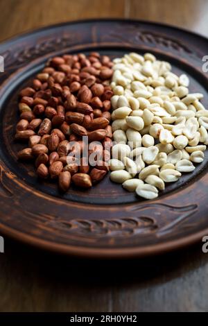 Cacahuètes crues dans un bol en argile. Cajou et haricots décortiqués Banque D'Images