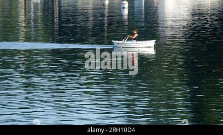 Bateau à rames femme à travers une baie Banque D'Images